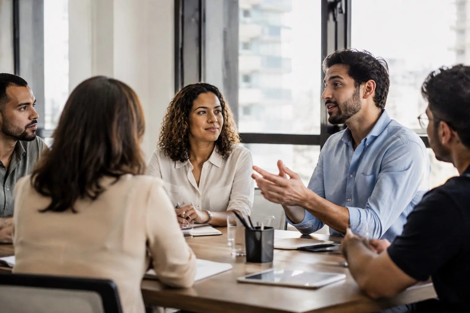 Profissionais em uma sala de reunião clara, uma pessoa explicando
